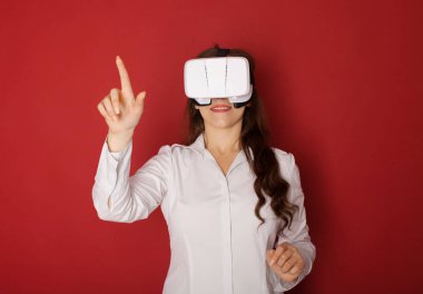 Sanal gerçeklik (Vr) gözlüklü genç kadın. Kırmızı zemin üzerine izole