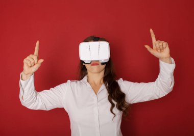 Sanal gerçeklik (Vr) gözlüklü genç kadın. Kırmızı zemin üzerine izole