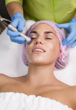 Radyo frekansı yüzünde kaldırma almak güzel bir kadın. Profesyonel Şevval Özçelik Güzellik yüz anti-kırışıklık tedavisi yapıyor. Cilt Bakımı ve cilt dokusunu düzeltilmesi kavramı.