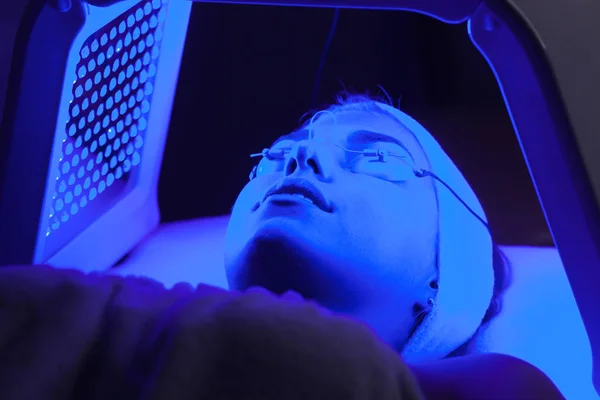 Genç kadın güzellik salonu LED ışık yüz tedavisi sahip