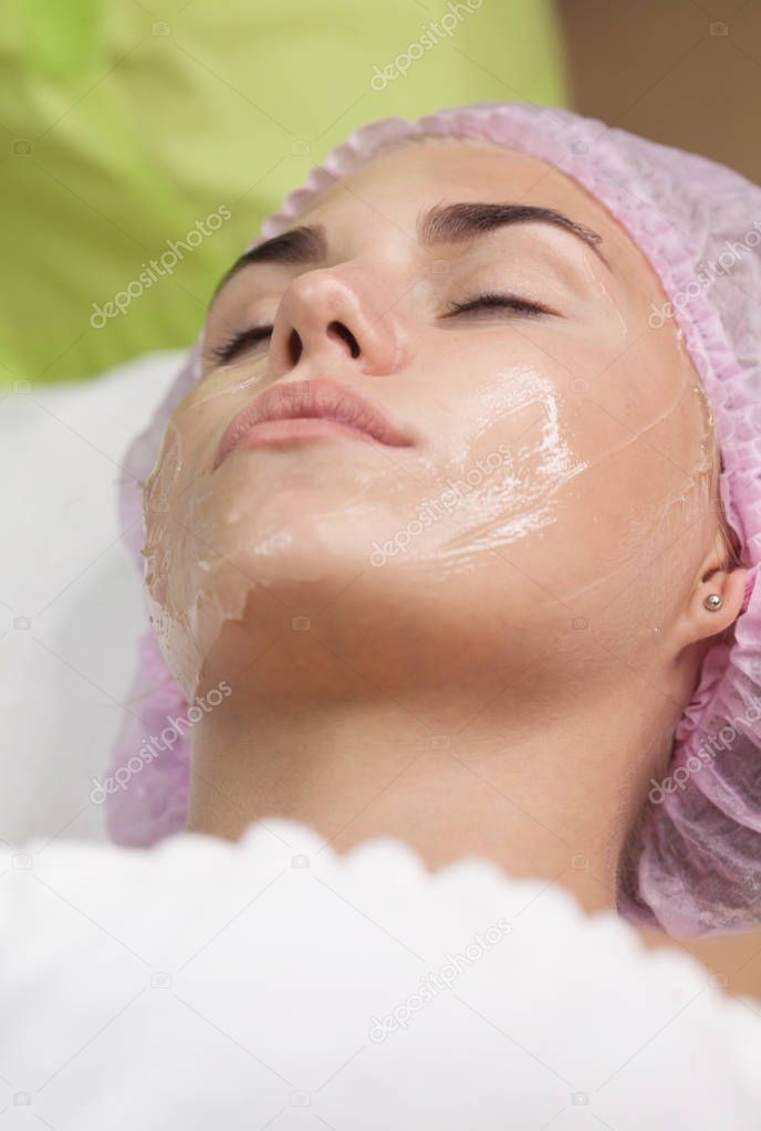 Doctor applies Hydro gel Mask on the woman face. Before young woman receiving laser treatment.