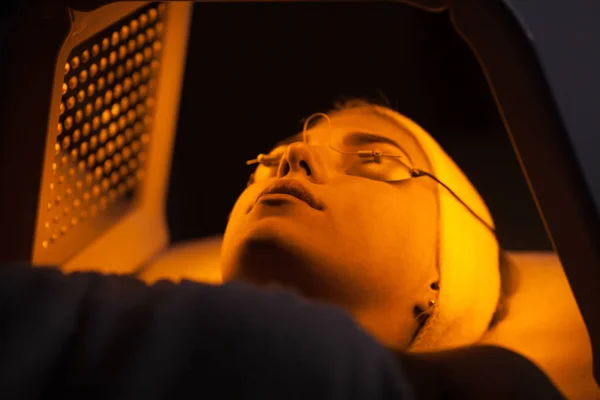 Genç kadın güzellik salonu LED ışık yüz tedavisi sahip