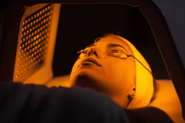 Genç kadın güzellik salonu LED ışık yüz tedavisi sahip