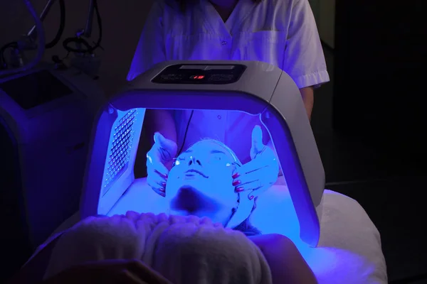 Genç kadın güzellik salonu LED ışık yüz tedavisi sahip