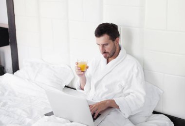 yatmadan dizüstü kullanan genç adam