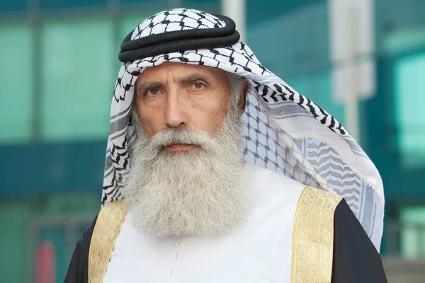 Outdoor Portrait of serious bearded Senior Arab man.
