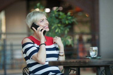 Cep telefonu üzerinde konuşurken güzel ve mutlu orta yaşlı kadın