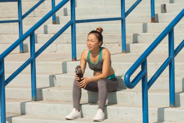 Yaz merdivenlerde, güzel kadın içme suyu. Sağlıklı yaşam konsepti