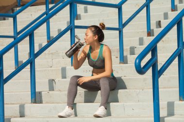 Yaz merdivenlerde, güzel kadın içme suyu. Sağlıklı yaşam konsepti