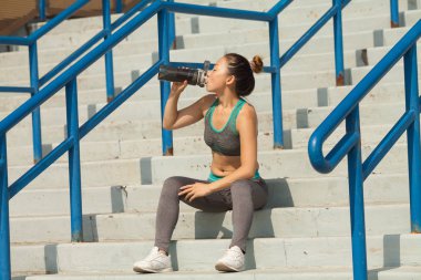 Yaz merdivenlerde, güzel kadın içme suyu. Sağlıklı yaşam konsepti