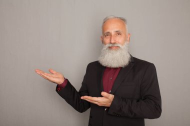 Parmak uzakta üzerinde gri arka plan işaret mutlu yaşlı sakallı işadamı portresi