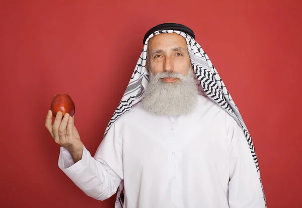 Vieux Barbu Arabe Avec Pomme Rouge Isolé Sur Rouge — Photo