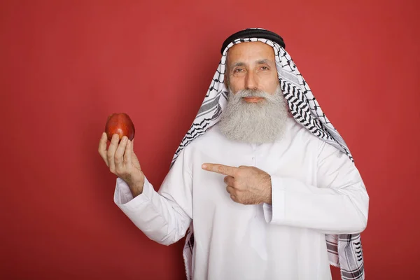 Velho Homem Árabe Barbudo Com Maçã Vermelha Isolada Vermelho — Fotografia de Stock