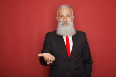 Gülümseyen ve bir elinde hayali bir şey kırmızı arka plan üzerinde tutan sakallı komuta sizde