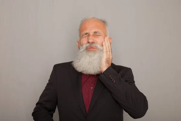 Portrait of bearded senior man having terrible toothache