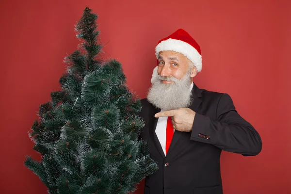 Senior Szakállas Üzletember Santa Kalap Piros Háttéren Karácsonyfa — Stock Fotó