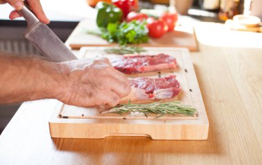 Biberiye Biber tuz çatal ve kesici bir kesme tahtası üzerinde ham sığır bonfile biftek.