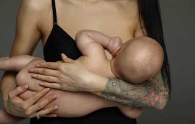 Ellerde yeni doğan bebek bebek ile mutlu anne ayakta ve breasfeeding emzirme emzirme sağlık ve bakım bağ zaman kavramı