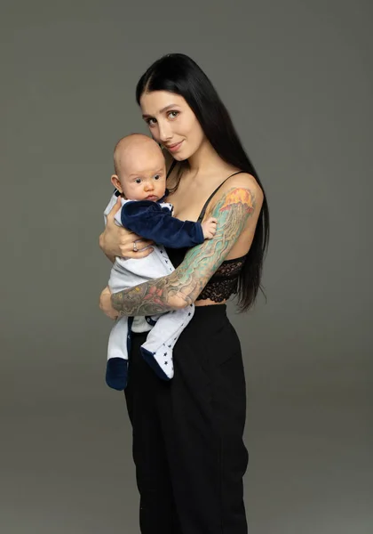 母亲抱着婴儿在灰色背景 — 图库照片