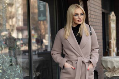 Yüksek moda portre genç zarif sarışın kadının açık. Trendy ceket, güneş gözlüğü.