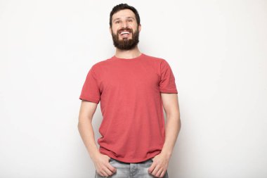 Gri arka planda izole genç şaşkın sakallı adam portresi