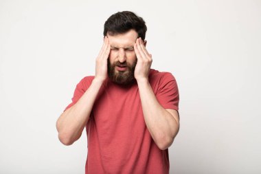 Korkunç bir baş ağrısı hissediyorum. Genç sakallı adamın portresi acı çekerken ayakta duruyor ve tapınaklarına dokunuyor. Gözlerini kapalı tutarken kaşlarını çatıyor.