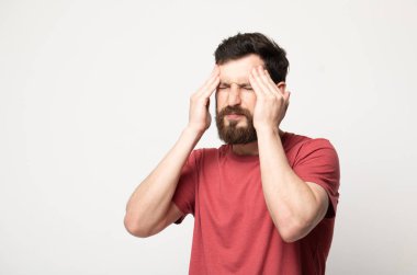 Korkunç bir baş ağrısı hissediyorum. Genç sakallı adamın portresi acı çekerken ayakta duruyor ve tapınaklarına dokunuyor. Gözlerini kapalı tutarken kaşlarını çatıyor.