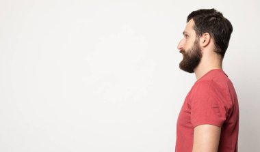 Gri arka planda izole genç şaşkın sakallı adam portresi