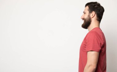 Gri arka planda izole genç şaşkın sakallı adam portresi