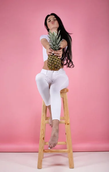 Güzel Seksi Genç Kız Ananas Ile Pembe Bir Arka Plan — Stok fotoğraf