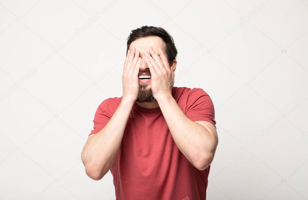 smiling man closing his eyes over gray background