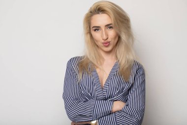 Temiz cilt, doğal makyaj ve gri arka plan çizgili elbise beyaz dişleri ile güzel gülümseyen kadın