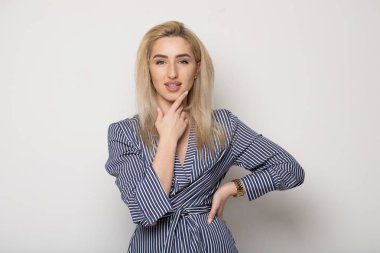 Temiz cilt, doğal makyaj ve gri arka plan çizgili elbise beyaz dişleri ile güzel gülümseyen kadın