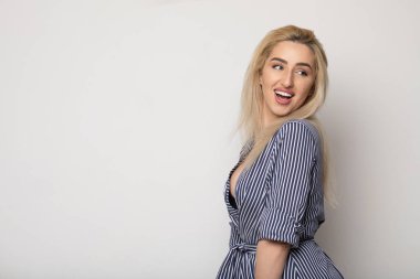 Temiz cilt, doğal makyaj ve gri arka plan çizgili elbise beyaz dişleri ile güzel gülümseyen kadın