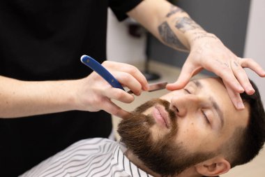 Sakal ve bıyık kuaför dükkanında bakım sırasında istemci