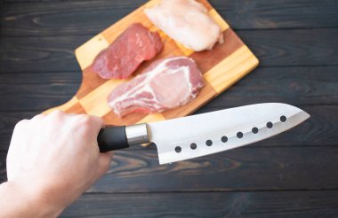 Kasap bıçağı ile ahşap arka plan üzerinde kemik, domuz eti ve tavuk fileto çiğ et eti Çeşitleri, üst görünümü