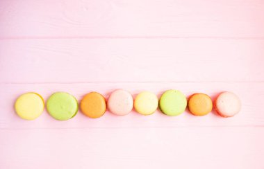 Pembe bir arka plan üzerinde renkli macaroons.