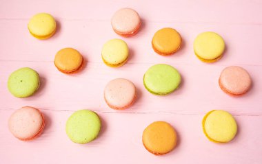 Pembe bir arka plan üzerinde renkli macaroons.