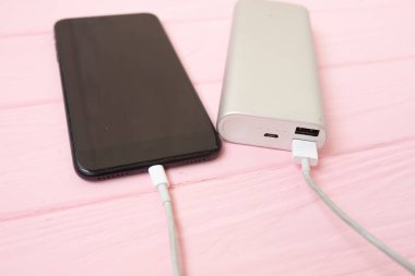 Banka ahşap arka plan üzerinde siyah smartphone ve güç