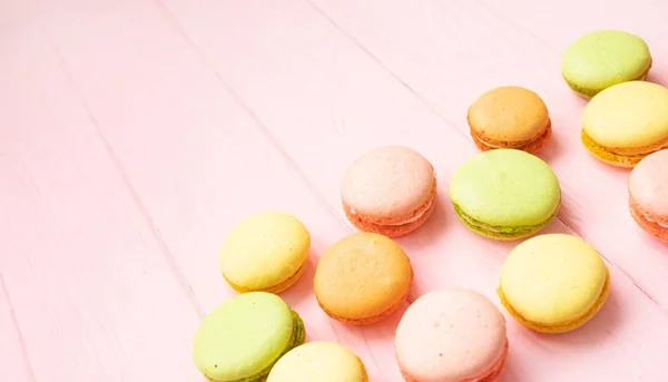 Multicolored macaroons on pink background.