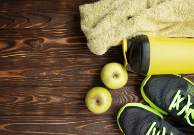 Spor malzemeleri - spor ayakkabı, su6 havlu. Ahşap zeminde spor arka plan, üst görünüm .