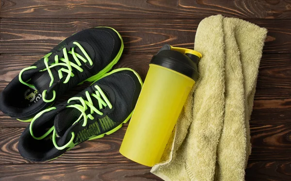 Sports equipment - sneakers, water6 towel. Sport background on wooden floor, top view .