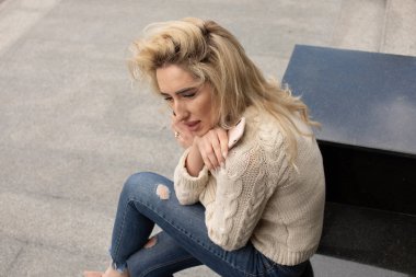 Yaz günü ve holding cep telefonu üzerinde bağdaş ile sokak merdivenlerde oturan güzel şık kadın görüntüsünü