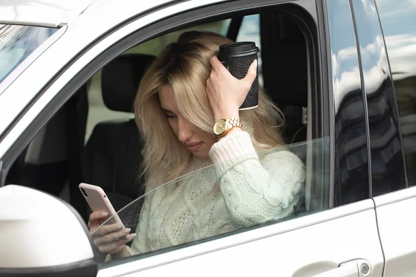 Hermosa Mujer Está Sentada Conduciendo Coche Ella Sostiene Teléfono Móvil — Foto de Stock