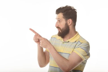 Şaşırttı mutlu sakallı adam gömlek uzakta işaret ve beyaz arka plan üzerinde kameraya bakarak.