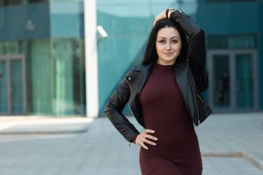 Açık poz uzun esmer saçlı Inanılmaz neşeli güzel kız. Deri ceket, esmer saçlı. Moda sokak stile portre.