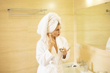 bornoz ve havlu banyo aynaya bakarak kafasına güzel gülümseyen genç kadın