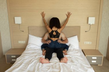 Genç çok ırklı seksi çift kanepe üzerinde siyah giyim.