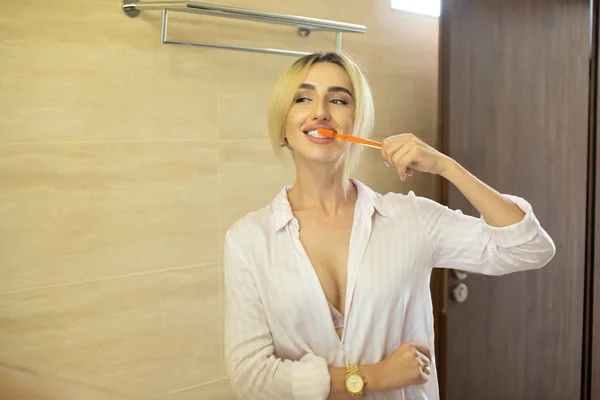 Όμορφη Νεαρή Γυναίκα Βουρτσίζετε Δόντια Μπροστά Από Τον Καθρέφτη Του — Φωτογραφία Αρχείου