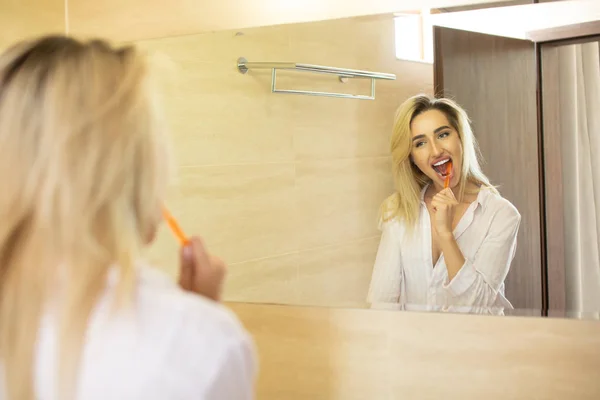 Όμορφη Νεαρή Γυναίκα Βουρτσίζετε Δόντια Μπροστά Από Τον Καθρέφτη Του — Φωτογραφία Αρχείου